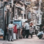 A glimpse into the vibrant street life of a traditional hutong in Beijing, China, showcasing daily interactions.